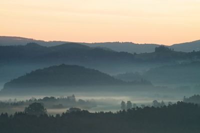 Hills and forests lines in mountain valley during autumn sunset. natural mountain landscape in mist