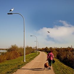 Rear view of women on street against sky