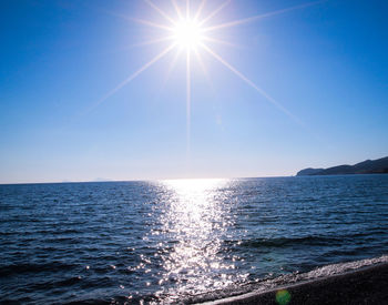 Scenic view of sea against clear sky on sunny day