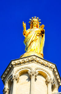 Low angle view of statue of temple against clear blue sky