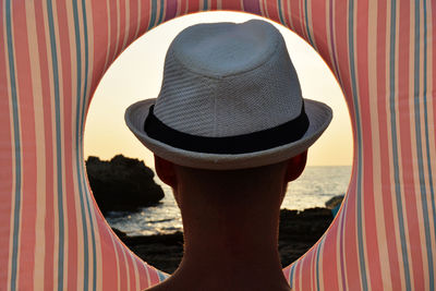 Man looking at sea through inflatable ring