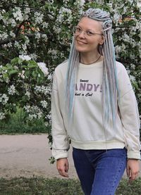 Young woman standing against trees