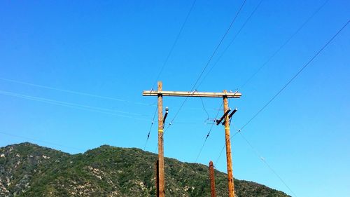 Low angle view of power lines against clear sky