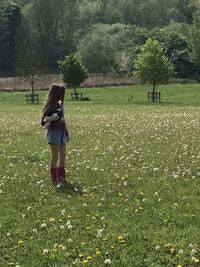 Rear view of woman standing on field