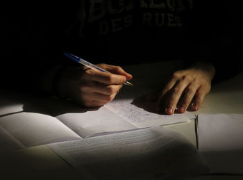 Cropped hands of woman writing on paper