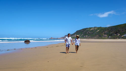 Rear view of woman walking at beach