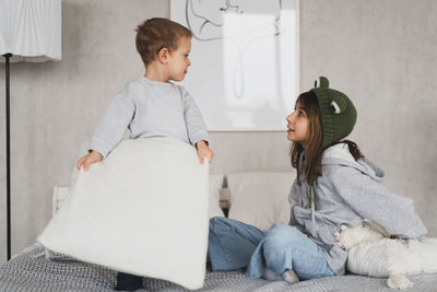 Side view of mother and daughter on bed at home