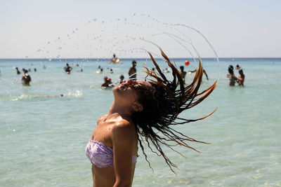 Woman tossing hair in sea