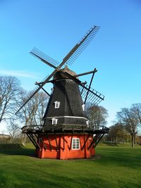 Traditional windmill on field against sky