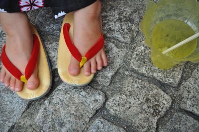 Low section of woman by drink on footpath