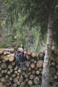 Full length of man climbing on log in forest