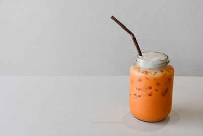 Close-up of drink on table against white background