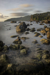 Scenic view of rocks on beach against sky