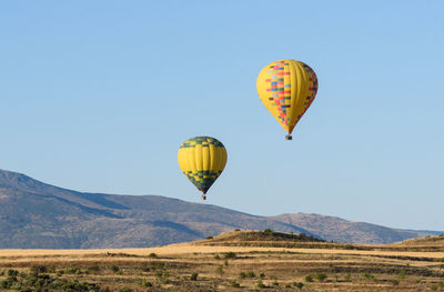 Hot air balloon flying over mountain against sky