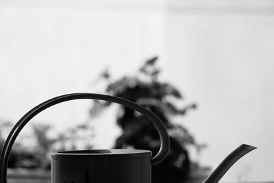 Close-up of cropped watering can against clear sky