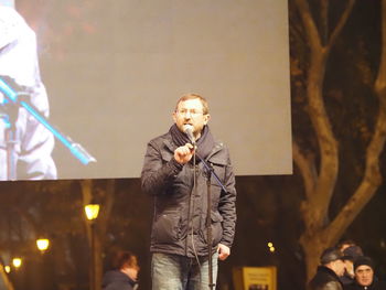 Full length of man holding umbrella standing at night