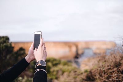 Cropped image of woman hands photographing through smart phone