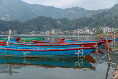 View of boats moored in lake against mountains