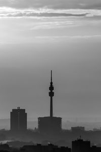 Buildings in city against cloudy sky