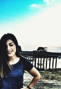 Young woman standing at beach against clear sky