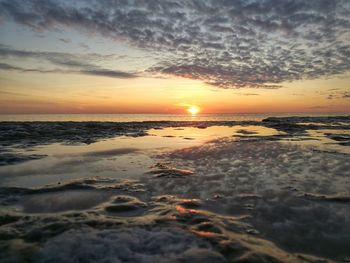 Scenic view of beach against sky during sunset