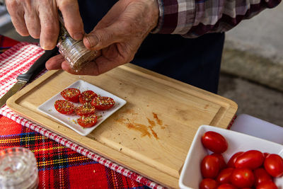 Midsection of man garnishing tomatoes