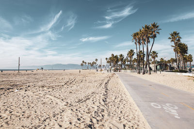 Surface level of road on beach against sky