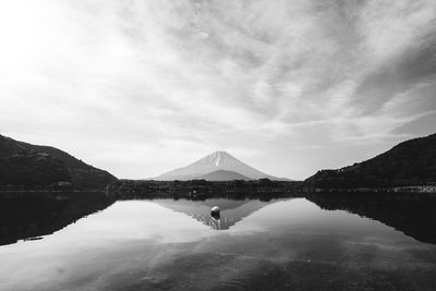 Scenic view of lake by mountains against sky