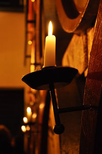 Close-up of lit candle in church