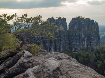 Sunset above sharp sandstone cliffs schrammsteine above deep valley. popular climbers resort.