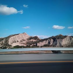 Road by mountains against blue sky