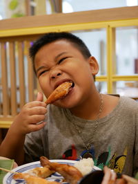 Portrait of boy eating food in restaurant