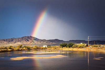 Scenic view of mountains against rainbow in sky