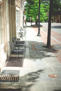 Empty footpath amidst buildings in city