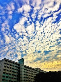 Low angle view of buildings against cloudy sky