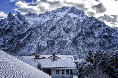 Houses on snowcapped mountain against sky