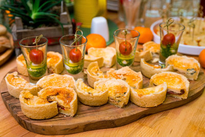 Catering appetizers on the table. shot glasses with caprese canapés and slices of mini quiché 