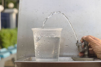 Close-up of hand holding glass of water