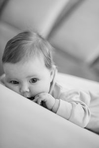 Close-up of cute baby boy lying on bed at home