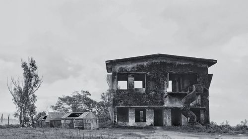 Old house on field against sky