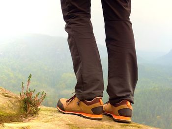 Low section of man standing on mountain