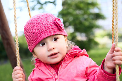 Portrait of cute girl holding pink hat