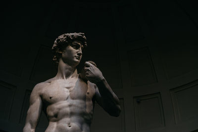 Low angle view of shirtless man standing at home