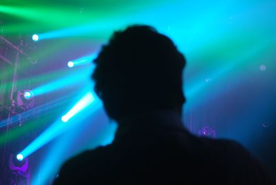 Rear view of silhouette man at music concert