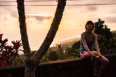 Woman standing on tree trunk