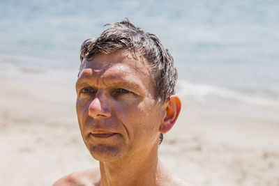 Close-up of shirtless man at beach during sunny day