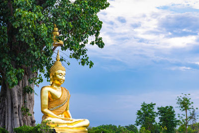 Low angle view of statue against trees and sky