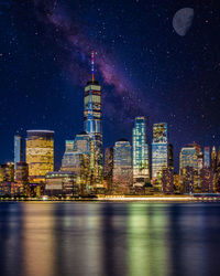 Illuminated buildings against sky at night