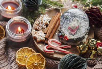 A snow globe and christmas candles with branches of fir. christmas decorations.