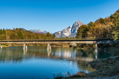 Scenic view of lake and mountains against clear blue sky